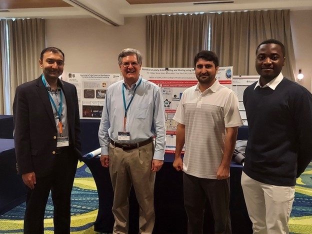 Bukhari Lab members and collaborators standing in front of research posters at FLAIRS-35.